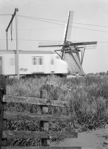 881612 Afbeelding van een electrisch treinstel mat. 1964 (plan V) van de N.S. ter hoogte van de molen van Hazerswoude.
